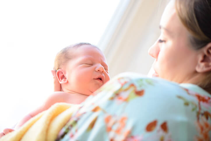 Nøgen baby hos mor på en varm sommerdag