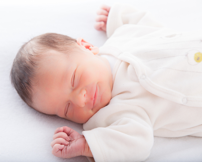 Baby smiler I søvne